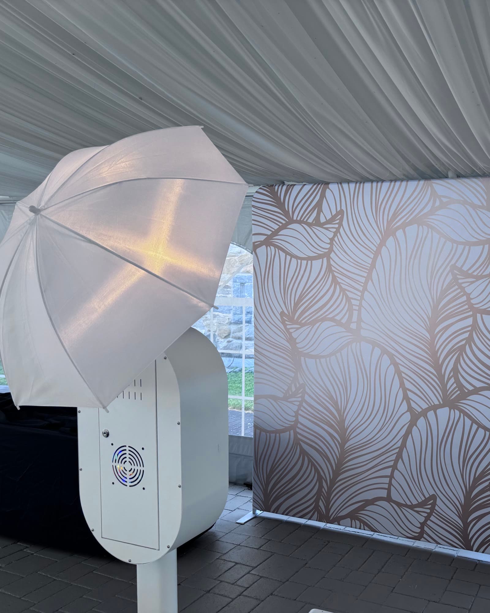 The Sonify photobooth set up inside a tent, umbrella flash beside the gold-leaf backdrop