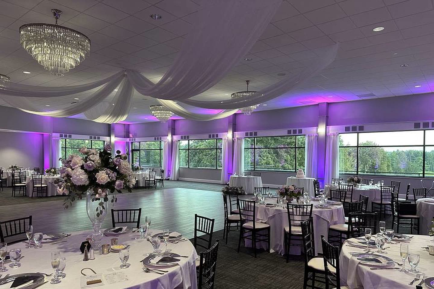The same ballroom washed in violet uplighting