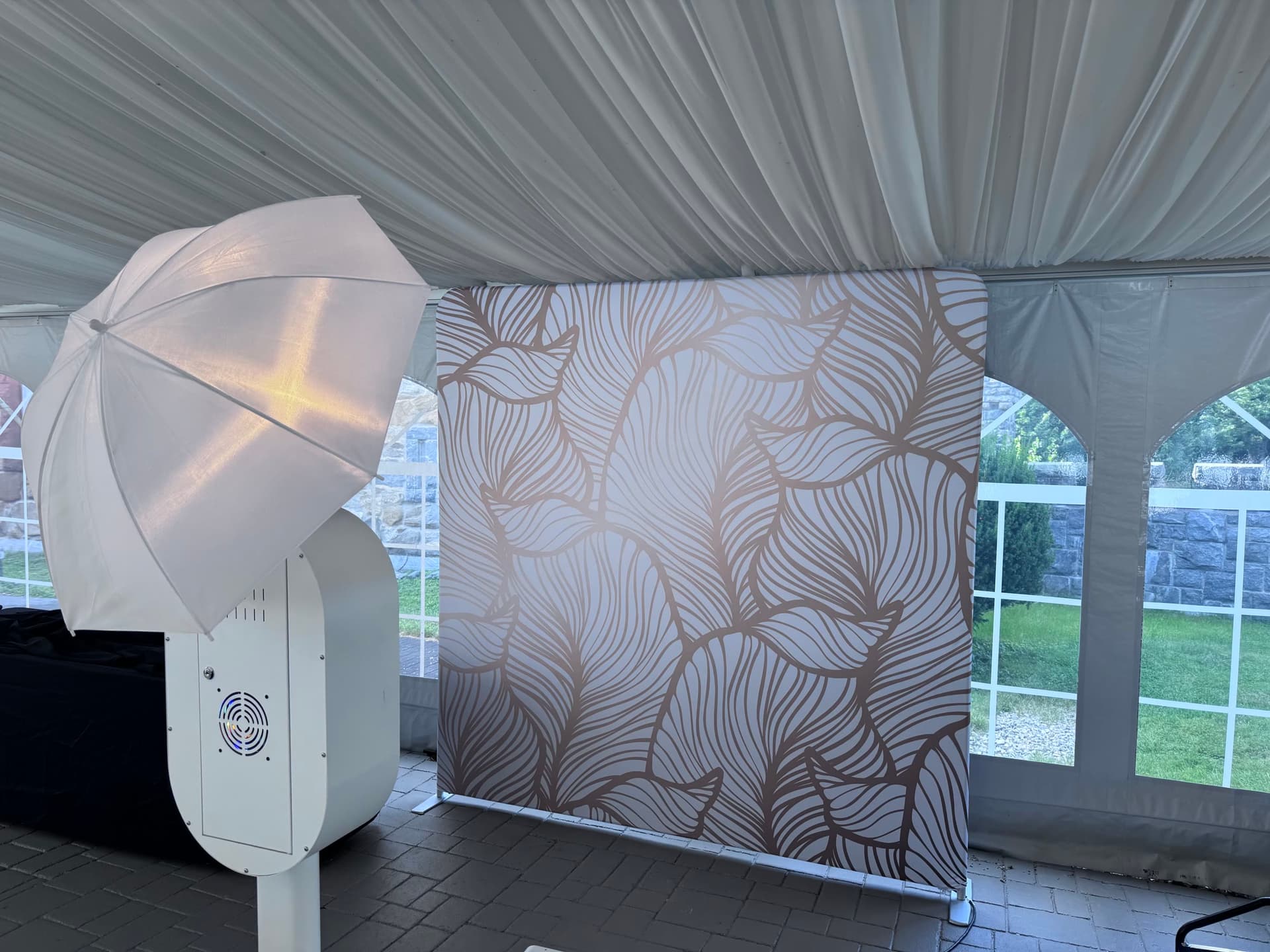 The Sonify photobooth set up inside a tent, umbrella flash beside the gold-leaf backdrop